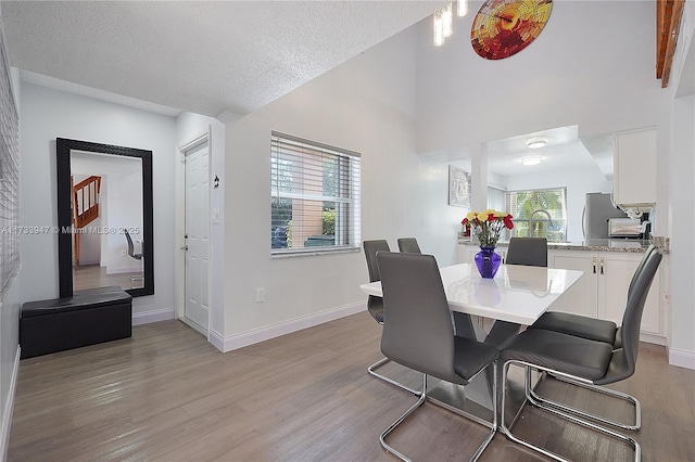 dining room with a textured ceiling and light hardwood / wood-style flooring