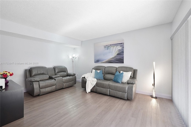 living room featuring a textured ceiling and light hardwood / wood-style floors