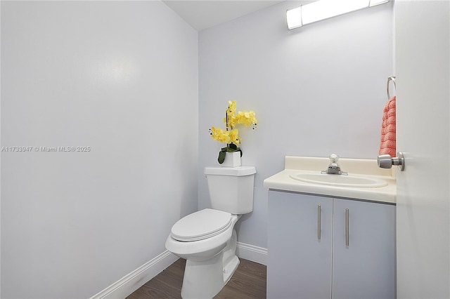 bathroom with wood-type flooring, toilet, and vanity