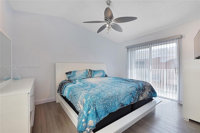 bedroom featuring hardwood / wood-style flooring, lofted ceiling, access to outside, and ceiling fan