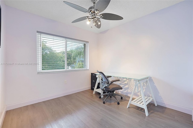 home office with wood-type flooring, ceiling fan, and a textured ceiling