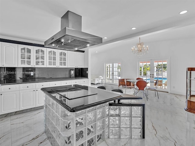 kitchen featuring french doors, tasteful backsplash, a kitchen island, island exhaust hood, and white cabinets