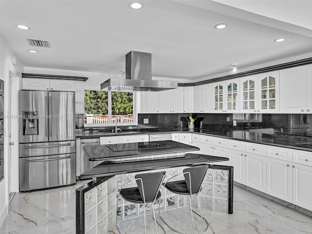 kitchen with sink, island range hood, stainless steel fridge, and white cabinets