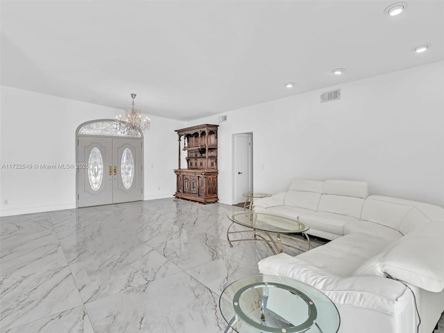 living room featuring french doors and a chandelier