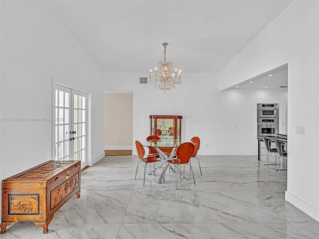 dining room featuring a notable chandelier, vaulted ceiling, and french doors