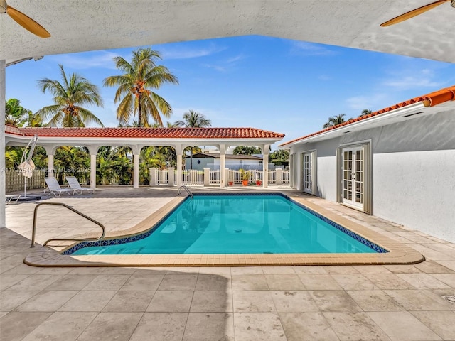 view of pool featuring a patio area, ceiling fan, and french doors