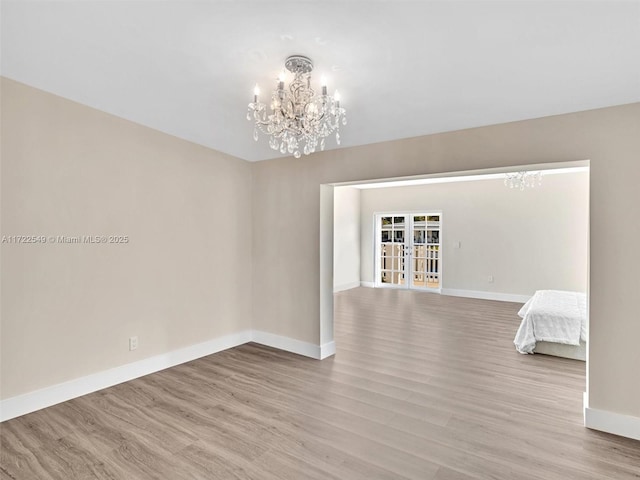 12904 Banyan Rd, North Miami, FL 33181 - empty room featuring a chandelier, wood finished floors, and baseboards