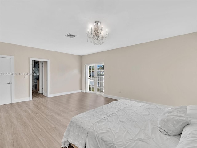 bedroom featuring light hardwood / wood-style floors and a chandelier