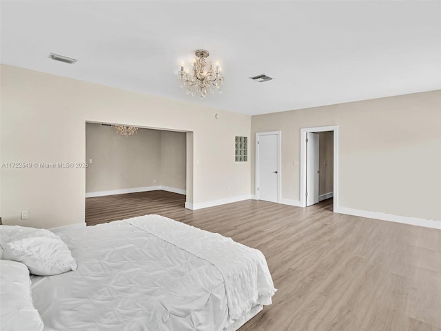 bedroom with hardwood / wood-style floors, a notable chandelier, and a closet