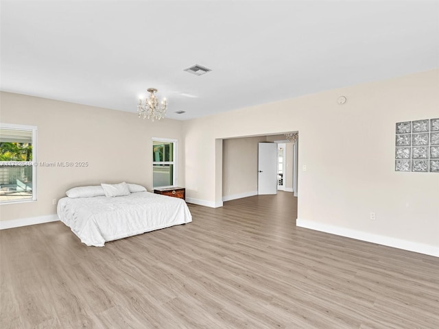 bedroom featuring a notable chandelier and light hardwood / wood-style flooring