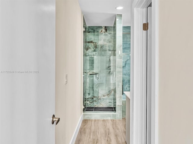 bathroom with wood-type flooring and an enclosed shower