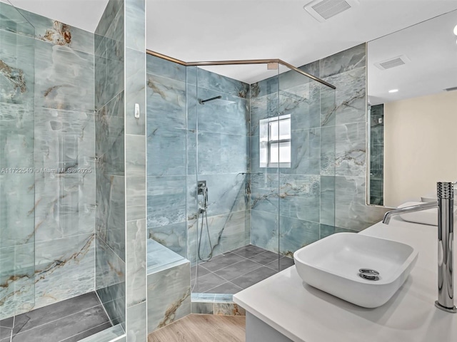 bathroom featuring vanity, hardwood / wood-style floors, and tiled shower