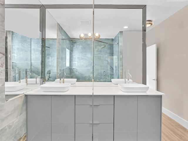 bathroom with vanity, a shower with shower door, and wood-type flooring