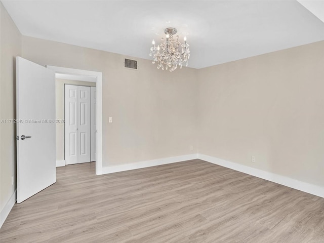 12904 Banyan Rd, North Miami, FL 33181 - unfurnished room featuring a chandelier, light wood finished floors, and baseboards
