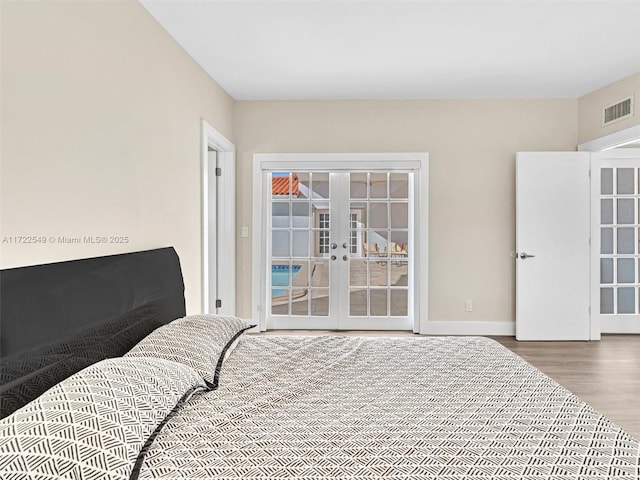 bedroom with wood-type flooring and french doors