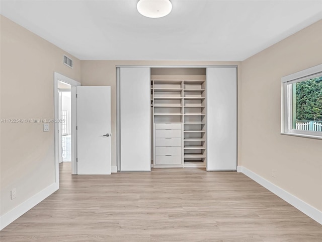 unfurnished bedroom featuring light hardwood / wood-style floors and a closet