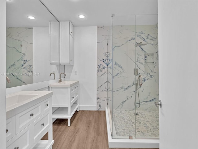 bathroom with wood-type flooring, an enclosed shower, and vanity