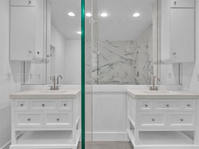 bathroom featuring vanity and a shower with door