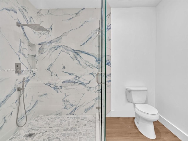 12904 Banyan Rd, North Miami, FL 33181 - bathroom with a marble finish shower, toilet, wood finished floors, and baseboards