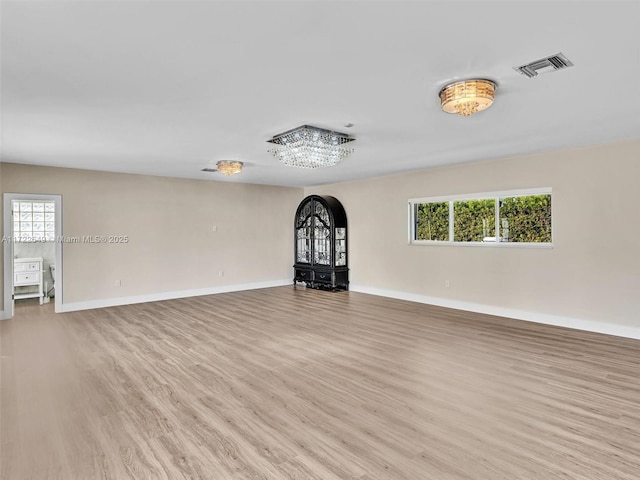 12904 Banyan Rd, North Miami, FL 33181 - unfurnished living room featuring arched walkways, light wood-type flooring, and baseboards