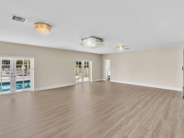 unfurnished living room with french doors and light wood-type flooring