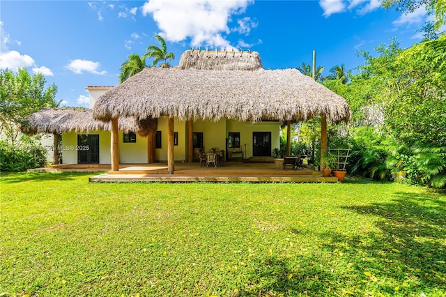 back of property with a wooden deck and a lawn