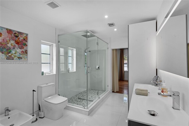 bathroom with a bidet, toilet, vanity, and a shower with shower door