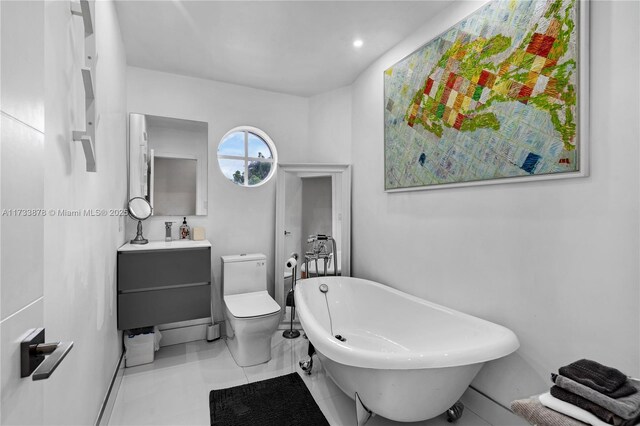 bathroom featuring a washtub, vanity, and toilet