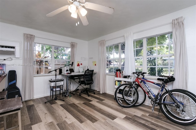 dining space featuring ceiling fan, light hardwood / wood-style flooring, and a wall mounted AC