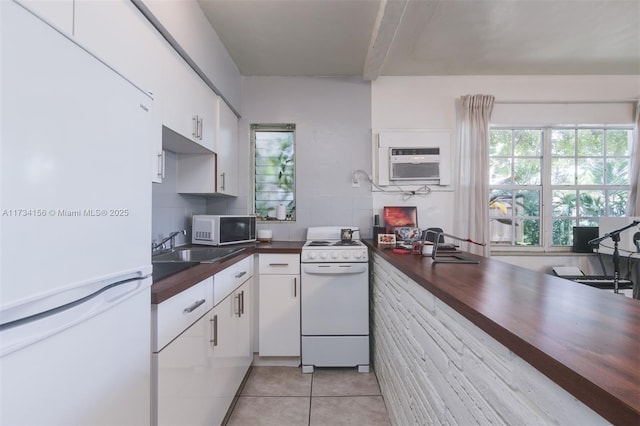 kitchen with a wall mounted AC, light tile patterned floors, white cabinets, white appliances, and backsplash