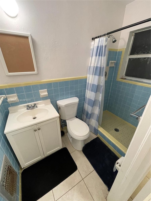 bathroom with tile walls, tile patterned flooring, vanity, walk in shower, and toilet