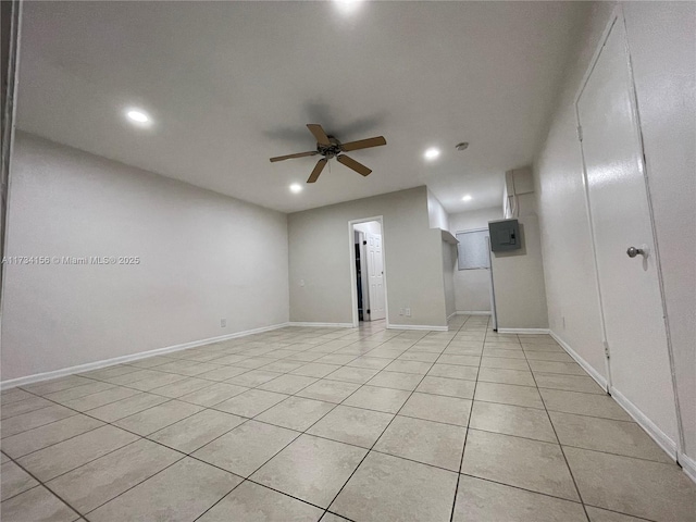 empty room featuring ceiling fan, electric panel, and light tile patterned floors