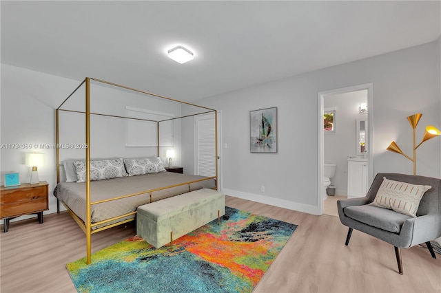 bedroom featuring ensuite bathroom and light hardwood / wood-style flooring