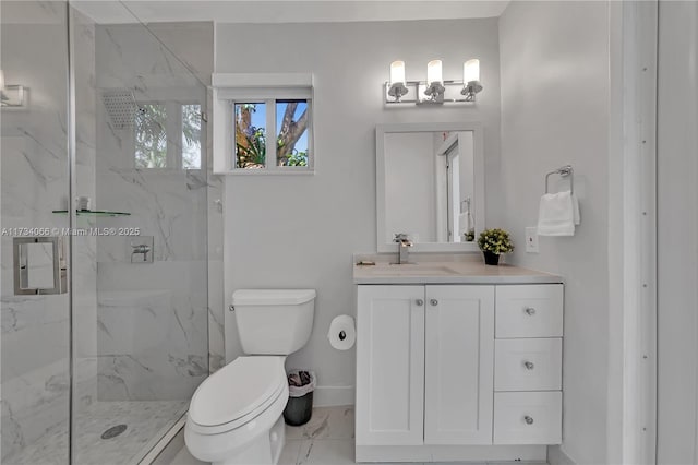 bathroom with vanity, a shower with door, and toilet