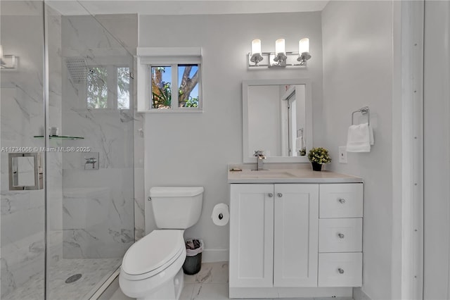 bathroom with toilet, vanity, and a shower with shower door