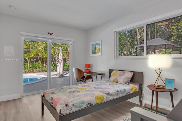 bedroom with access to exterior and light wood-type flooring