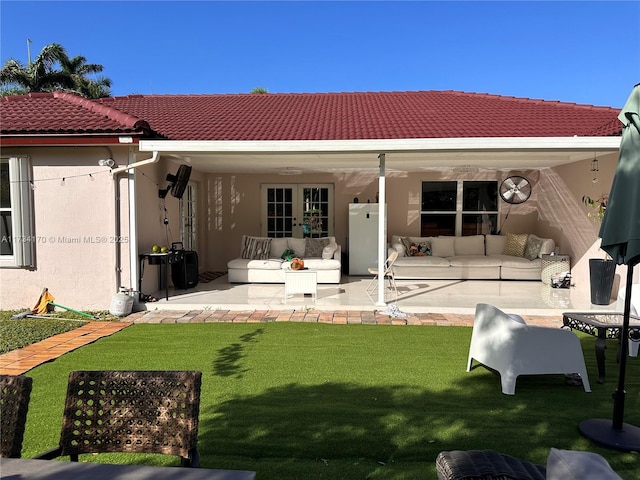 rear view of property featuring a lawn and a patio area