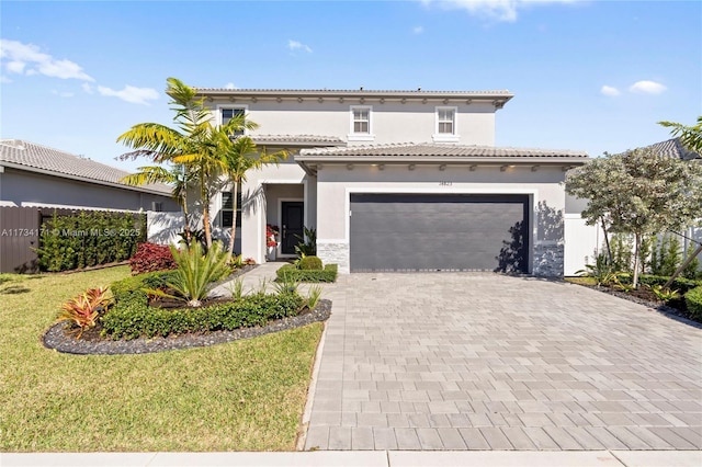 mediterranean / spanish house with a garage and a front lawn