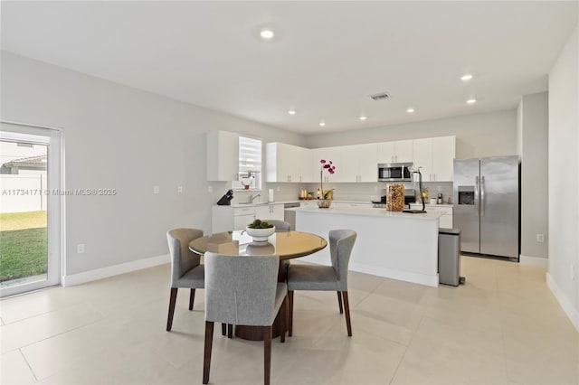 dining area featuring sink and light tile patterned floors