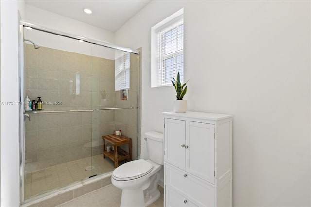 bathroom featuring a shower with shower door and toilet