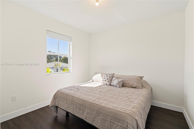 bedroom with dark hardwood / wood-style floors