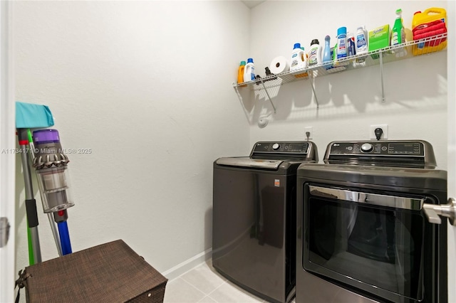 clothes washing area with light tile patterned floors and washer and clothes dryer