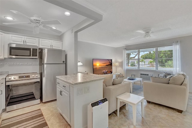 kitchen with ceiling fan, stainless steel appliances, a center island, white cabinets, and light tile patterned flooring