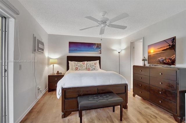 bedroom featuring ceiling fan, light hardwood / wood-style floors, and a textured ceiling