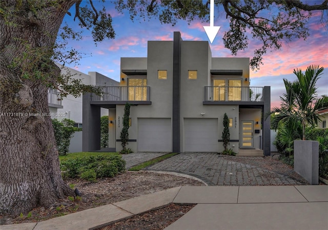 view of front of property featuring a garage and a balcony