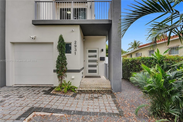 doorway to property featuring a garage and a balcony