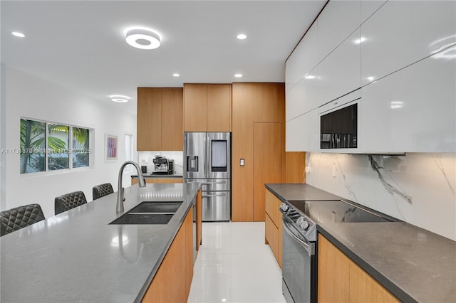 kitchen featuring sink, tasteful backsplash, a kitchen breakfast bar, stainless steel appliances, and white cabinets