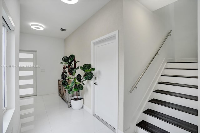 staircase featuring tile patterned flooring