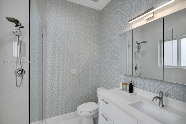 bathroom with tile walls, backsplash, vanity, tiled shower, and toilet