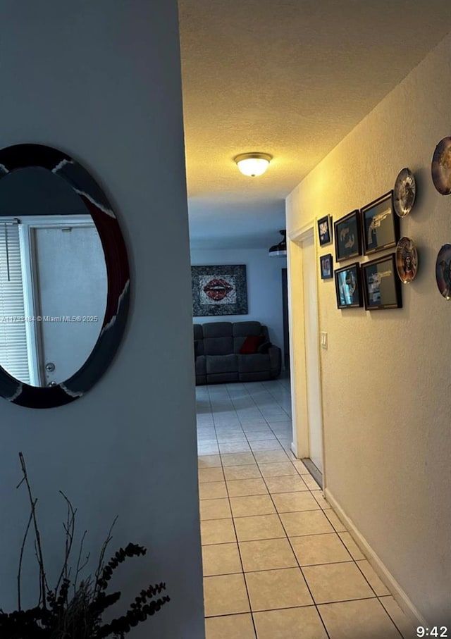 hallway featuring light tile patterned floors and a textured ceiling